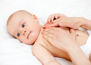 Masseuse massaging little baby girl, shallow focus